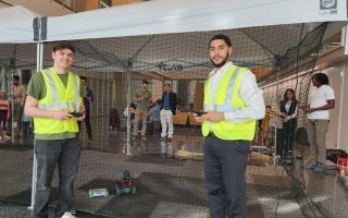 CEHC students Jay Parker and Hadley Santos control drones and robotics in the pop up tent at ETEC.