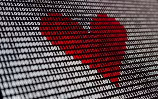 Image is of binary code - the digits one and zero. The numerals are white and the background is black. In the middle, the digits are rendered in red, forming form a heart shape. 