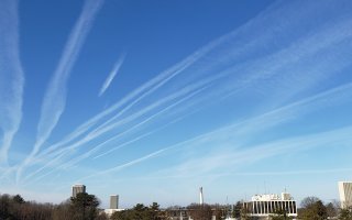 Contrails cover a blue sky above UAlbany's Uptown Campus. 