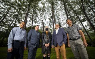 Department of Geography and Planning project researchers stand in front of a line of trees in the Academic Podium courtyard on the Uptown Campus.