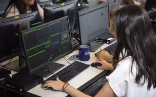 A female student works at a cybersecurity computer workstation inside the digital forensics lab at UAlbany.