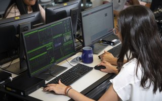A female student works at a cybersecurity computer workstation inside the digital forensics lab at UAlbany.