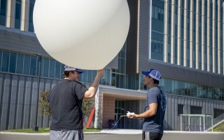 Eddie Megello and Nathan Meglio prepare a weather balloon for a practice launch from the ETEC parking lot.
