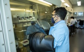 UAlbany chemist Jeremy Feldblyum conducts experiments inside a sealer container, called a glovebox, at his ETEC lab.