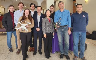 Students and faculty hold up mapping drones in the Lecture Center.