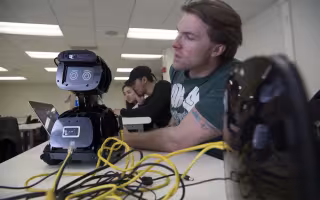 A student programs a robot in the lab at the College of Nanotechnology, Science, and Engineering.