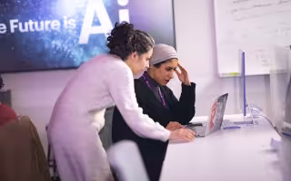 Graduate student researchers Mahsa Goodarzi and Rawan AlMakinah work together at CEHC’s AI in Complex Systems Lab.