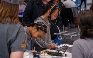 Two young students explore a table-top science experiment at STEM and Nanotechnology Family Day at UAlbany on Feb. 10, 2024.