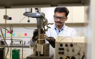 UAlbany PhD Student Sri Saravana Konganapuram Narasimma Bharathi works on a device in the lab of CNSE Professor Kathleen Dunn.