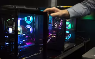 A hand reaches over the internal workings of computers