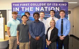 Marcie Fraser stands with EPICH students in front of a CEHC banner.