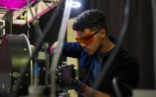 Student Kevin Reyes works in a lab at the College of Nanotechnology, Science, and Engineering.
