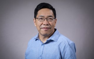 Headshot of Aiguo Dai wearing a blue button-down shirt.