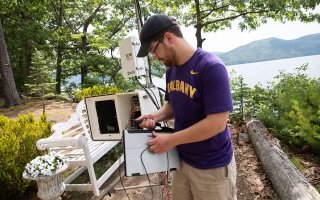 Jason Covert, a research technician at the Atmospheric Sciences Research Center and NYS Mesonet, prepares a land-based flux measurement system on Crown Island at Lake George.