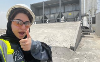 Bythaina Al Balushi gives a thumbs up with a hardhat on while working in Oman.