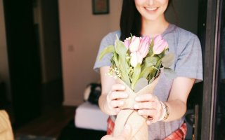 A woman receives a bouquet of tulips