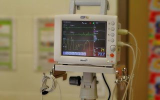 Hospital heart monitor device showing pulse readout on a digital screen