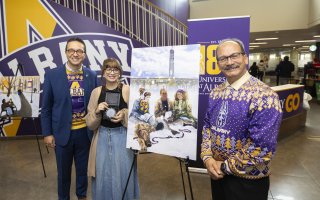 Aliyah Melendez, winner of UAlbany's Holiday Card contest, standing with VP Michael Christakis and President Havidán Rodríguez