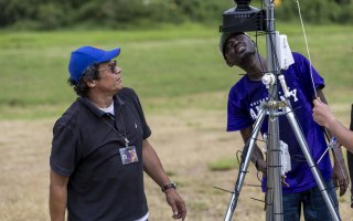 Jorge Gonzalez-Cruz works with a UAlbany student to install a specialized sensor that can monitor Puerto Rico's transmission towers.