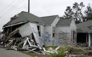 A damaged home with "do not demo" signage on it following Hurricane Katrina.