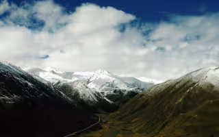 Snow covers the mountain tops on a cloudy day in the Tibet Autonomous Region of China.