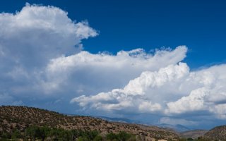 Puffy, white Cumulus clouds seen above the Capitan Mountains in New Mexico.