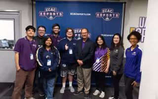 President Rodriguez stands with the UAlbany Esports team in front of an ECAC Esports banner.