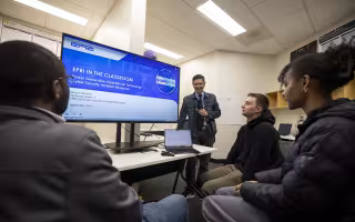 CEHC's Ariel Pinto stands in front of an EPRI presentation at the Cyber Cascade Risk lab.