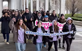 Students marching around UAlbany's podium in support of suicide prevention