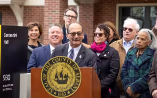 UAlbany President Havidan Rodriguez is joined by County Executive Dan McCoy at podium to announce purchase of Centennial Hall