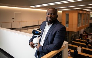 CEHC Benjamin Yankson holds a robot at the new ETEC building.