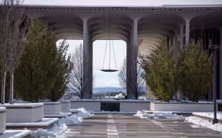 The UAlbany's uptown campus podium with some piles of snow left over from plowing. Low mountains can be seen in the distance