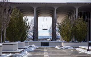 The UAlbany's uptown campus podium with some piles of snow left over from plowing. Low mountains can be seen in the distance