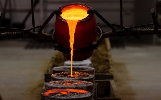 a crucible pours hot molten bronze into several casts during a crucible pour in UAlbany's Boor sculpture studio