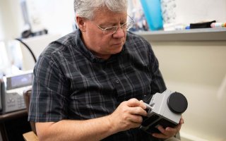 Kevin Knuth holds a device to study unidentified anomalous phenomena.