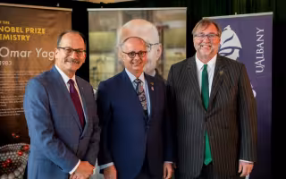 Omar Yaghi stands with UAlbany President Havidán Rodríguez and Hudson Valley President Michael Brophy 