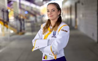 Grace Augenstern stands with her arms crossed in the Tom & Mary Casey Stadium concourse.