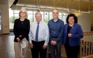 UAlbany faculty Elaine Salisbury, Kevin Knuth and Ryan Torn stand with College of Arts and Sciences Dean Jeanette Altarriba indoors.