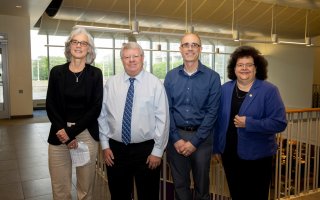 UAlbany faculty Elaine Salisbury, Kevin Knuth and Ryan Torn stand with College of Arts and Sciences Dean Jeanette Altarriba indoors.