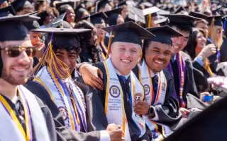 A crowd of graduates in graduation caps and gowns.