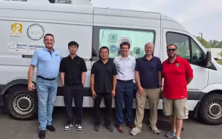 WNYT meteorologist Tim Drawbridge stands with researchers in front of ASRC's mobile air quality lab.