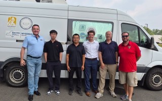 WNYT meteorologist Tim Drawbridge stands with researchers in front of ASRC's mobile air quality lab.