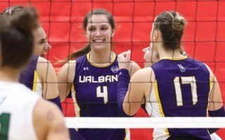 Shynelle Woroniuk with Volleyball team members on the court.