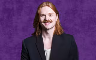a red-headed man in a black jacket