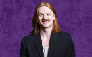 a red-headed man in a black jacket