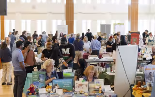 Patrons mull about the Campus Center ballroom at UAlbany moving through rows of books on display during the Albany Book Festival.