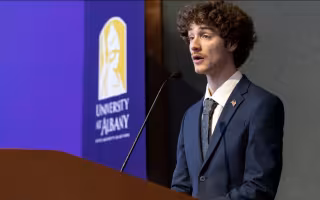 Junior Troy Serao delivers remarks from a UAlbany podium.