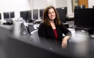 Anne McGrath sits in a computer lab.