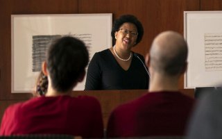 Professor Janell Hobson is framed by heads in the audience as she speaks from a podium