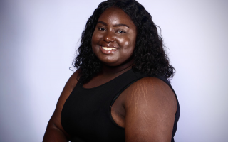 Eliane Alexandre, in a black tank top, smiles 